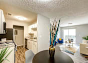 Thumbnail 5 of 29 - A modern kitchen with a dining table and chairs at Sedgefield Square Apartments, Greensboro, NC, 27407