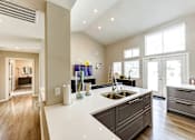 Thumbnail 13 of 29 - A modern kitchen with a white countertop and wooden cabinets at Sedgefield Square Apartments, North Carolina
