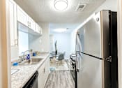 Thumbnail 1 of 29 - A kitchen with a black refrigerator and white cabinets at Sedgefield Square Apartments, North Carolina, 27407