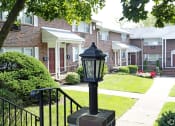 Thumbnail 16 of 16 - a lamp post in front of a brick building at Willow Gardens Apartments, Teaneck, NJ, 07666