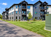Thumbnail 66 of 71 - A street view of apartment buildings with a green sign on the right.