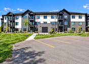 Thumbnail 13 of 71 - A large multi-story building with a parking lot in front.