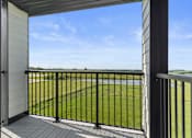 Thumbnail 15 of 22 - a balcony with a view of a field and a blue sky