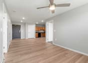 Thumbnail 11 of 22 - a living room with a ceiling fan and a door to a kitchen
