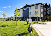Thumbnail 11 of 71 - A charging station for electric vehicles is in front of a building with the sign "Vue Pointe Apartments.".