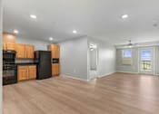 Thumbnail 14 of 22 - an empty living room with wood flooring and a kitchen