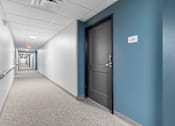 Thumbnail 10 of 22 - a hallway with blue walls and a door in a building