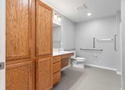 Thumbnail 20 of 22 - a bathroom with wooden cabinets and a toilet and a sink
