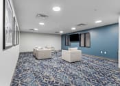 Thumbnail 7 of 22 - a community room with couches and chairs and a television