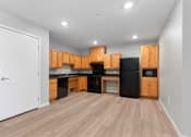 Thumbnail 12 of 22 - an empty kitchen with wooden cabinets and a black refrigerator