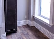 Thumbnail 7 of 9 - A tall dark brown cabinet stands in a room with a window.