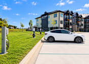 Thumbnail 71 of 71 - A white car is parked next to a charging station.