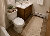 Thumbnail 18 of 20 - A bathroom with a toilet, sink, and mirror.