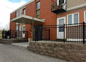 Thumbnail 1 of 15 - A red brick house with a black iron fence.