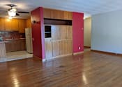 Thumbnail 5 of 15 - A kitchen with wooden floors and a red wall.
