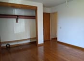 Thumbnail 8 of 15 - A room with a wooden floor and a sliding door.