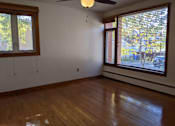 Thumbnail 9 of 15 - A room with a ceiling fan and two windows.