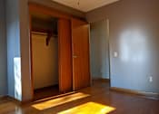 Thumbnail 10 of 15 - A room with a wooden door and a rug on the floor.