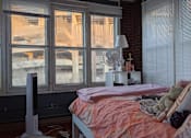 Thumbnail 6 of 9 - A bedroom with a bed, a fan, and a window with a view of a snowy landscape.