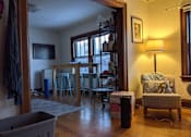 Thumbnail 3 of 9 - A room with a chair and a table in it.