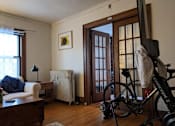 Thumbnail 4 of 9 - A room with a bicycle leaning against a wall.