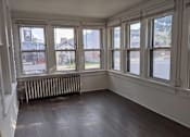 Thumbnail 24 of 29 - A room with white walls and a wooden floor with a window and a radiator.