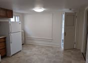 Thumbnail 25 of 29 - A white refrigerator in a kitchen with a tiled floor.