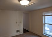 Thumbnail 27 of 29 - A room with a window and a carpet on the floor.