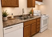 Thumbnail 4 of 20 - A kitchen with white appliances and wooden cabinets.