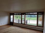Thumbnail 3 of 15 - A room with a large window and a view of a street.