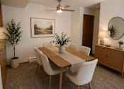 Thumbnail 12 of 20 - A dining room with a table, chairs, and a potted plant.
