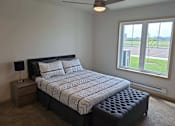 Thumbnail 14 of 34 - a bedroom with a bed and a large window