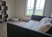 Thumbnail 18 of 34 - a bedroom with a bed and a large window