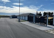 Thumbnail 23 of 34 - A long, paved road leads to a row of garages.
