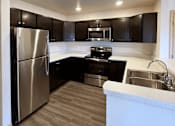 Thumbnail 9 of 34 - a kitchen with stainless steel appliances and black cabinets