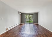 Thumbnail 13 of 19 - A room with a wooden floor and a sliding glass door.
