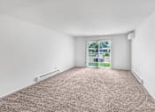 Thumbnail 15 of 19 - A room with a carpeted floor and a window with a view of a fence and trees.