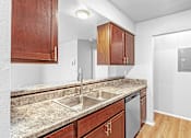 Thumbnail 6 of 19 - A kitchen with a sink and a refrigerator.