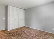 Thumbnail 20 of 20 - A room with a carpeted floor and a white closet with doors.