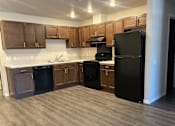 Thumbnail 3 of 21 - A kitchen with black appliances and wooden cabinets.