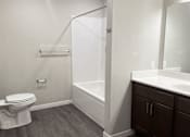 Thumbnail 7 of 21 - A white toilet sits in a bathroom next to a walk-in shower.