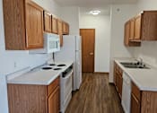 Thumbnail 6 of 22 - A kitchen with wooden cabinets and a white fridge.