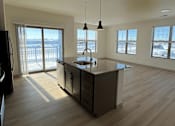 Thumbnail 8 of 54 - A kitchen with a wooden floor and a large island in the middle.