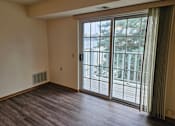 Thumbnail 6 of 11 - A room with a sliding glass door leading to a balcony.