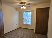 Thumbnail 7 of 11 - A room with a ceiling fan and a window.