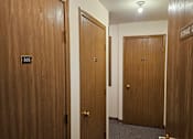 Thumbnail 9 of 11 - A hallway with doors and a sign that says "Storage Closet".