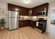Thumbnail 14 of 20 - A kitchen with wooden cabinets and a stainless steel refrigerator.