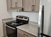 Thumbnail 5 of 54 - A kitchen with a stove top oven and a refrigerator.