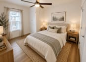 Thumbnail 7 of 20 - A bedroom with a large bed and a ceiling fan.
