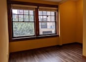 Thumbnail 4 of 29 - A room with a window and wooden floors.